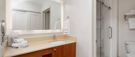 A modern bathroom with a sink, mirror, and shower.