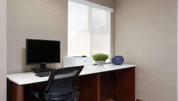 Un escritorio moderno con una computadora, una planta y un jarrón decorativo.
