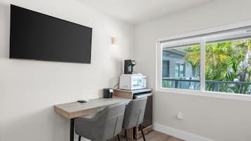 A modern kitchen with a built-in microwave, a coffee maker, and a large window offering a view of greenery outside.