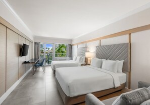 Habitació d'hotel amb dos llits, una taula de treball i una televisió.