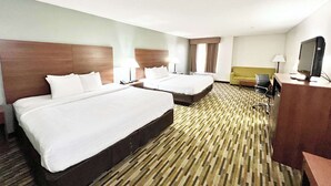 A hotel room with two beds, a desk with a computer, a sofa, and a TV. - Quality Inn Gainesville I-75 (Gainesville)