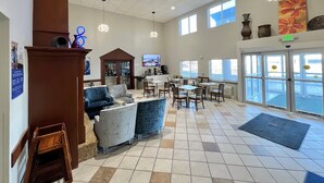 A spacious lobby with a seating area, a television, and a reception desk. - Baymont by Wyndham Litchfield (Litchfield)