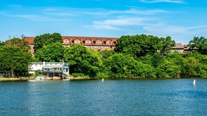 A riverside building with a dock, surrounded by lush greenery. - Riverview Inn & Suites, an Ascend Collection Hotel (Rockford)