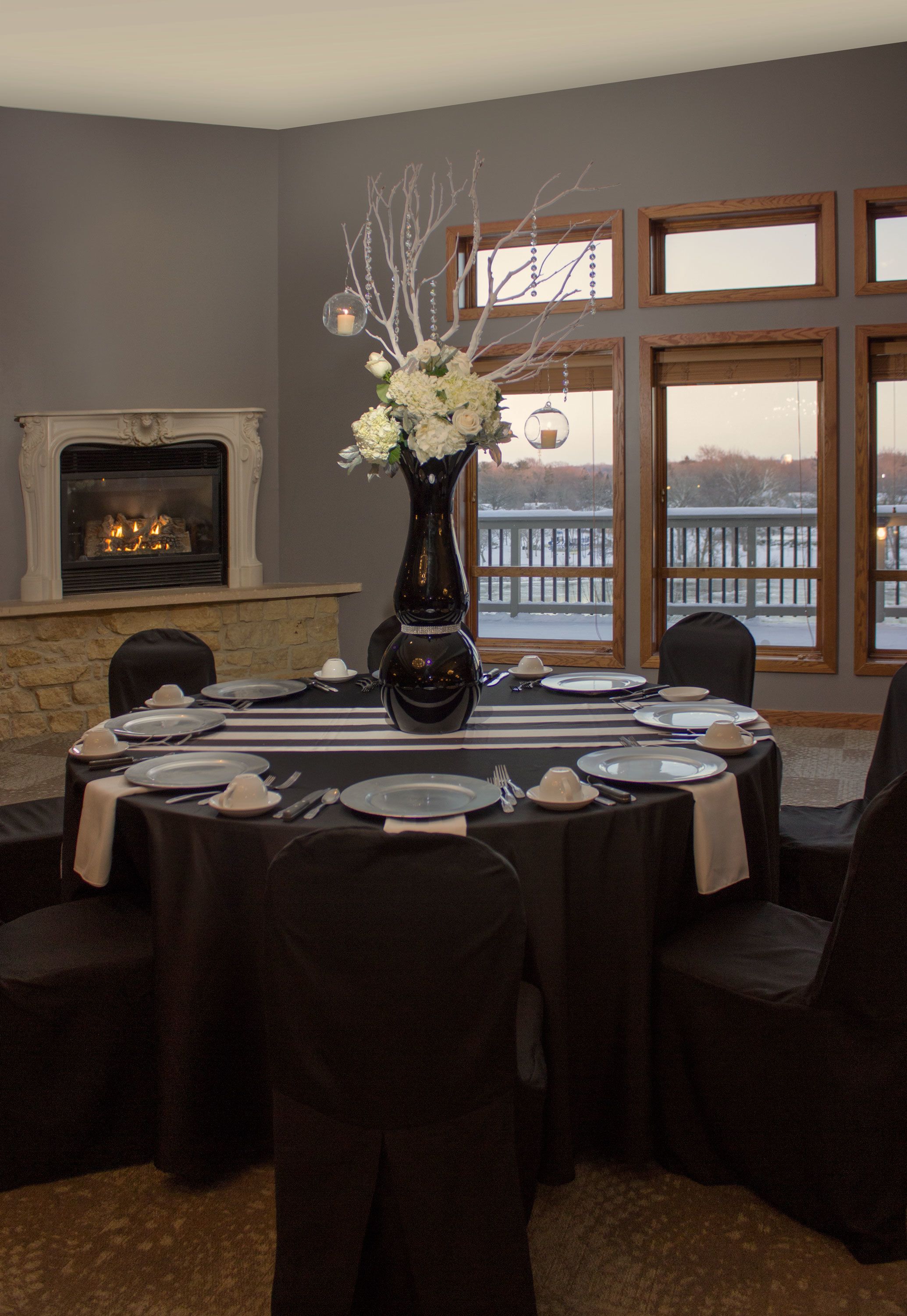 Comedor con chimenea, un amplio ventanal con vistas y una mesa dispuesta para seis comensales.