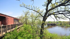 A riverside view with a wooden deck and a red building. - Riverview Inn & Suites, an Ascend Collection Hotel (Rockford)