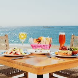 Dine al fresco with a view of the ocean from this beautifully set table for two.
