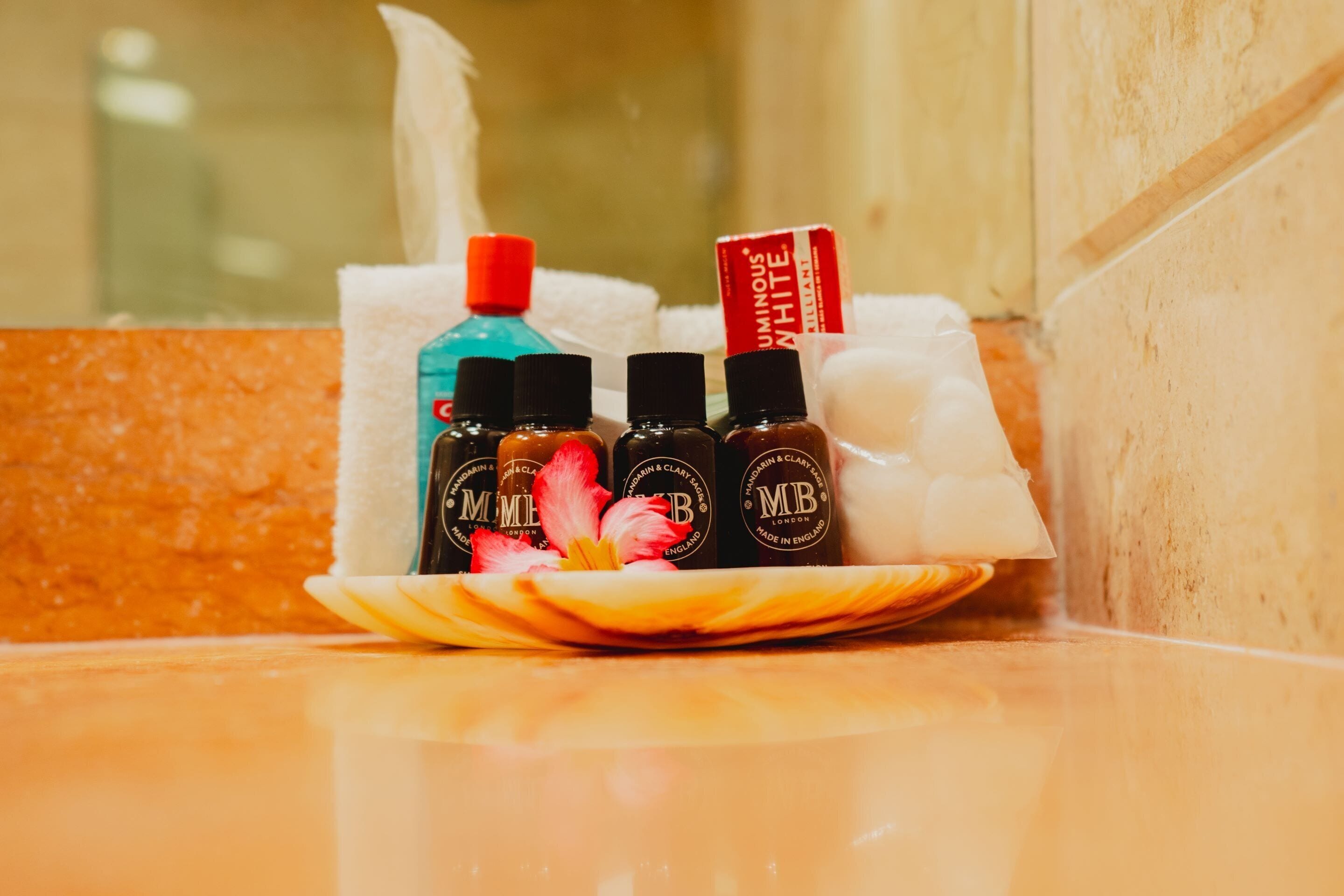 A tray with bottles of essential oils and a tissue box on a tiled surface.