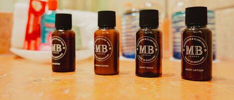 Four bottles of MB body care products on a countertop.
