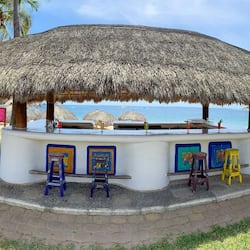 Relax by the ocean at our beachside bar, surrounded by palm trees and offering a serene atmosphere.