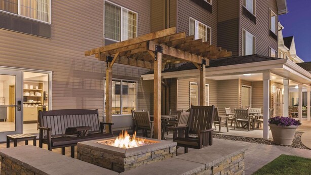 An outdoor patio area with a fire pit, seating, and a pergola. - Country Inn & Suites by Radisson, Albert Lea - Austin (Albert Lea)