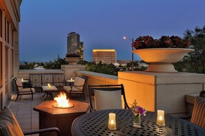 A rooftop terrace with outdoor seating, a fire feature, and a large planter with flowers. - Courtyard by Marriott Tysons McLean (McLean)