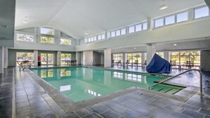 A large indoor swimming pool with clear water, surrounded by tiled flooring and multiple windows allowing natural light. - Holiday Inn Express Williamsburg North by IHG (Williamsburg)