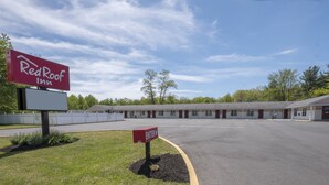 A Red Roof Inn with a large parking lot and a building with multiple rooms. - Red Roof Inn Neptune - Jersey Shore (Neptune City)