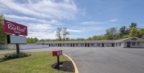 A Red Roof Inn with a large parking lot and a building with multiple rooms.