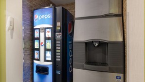 Una máquina expendedora de Pepsi y un dispensador de agua en el vestíbulo de un hotel.