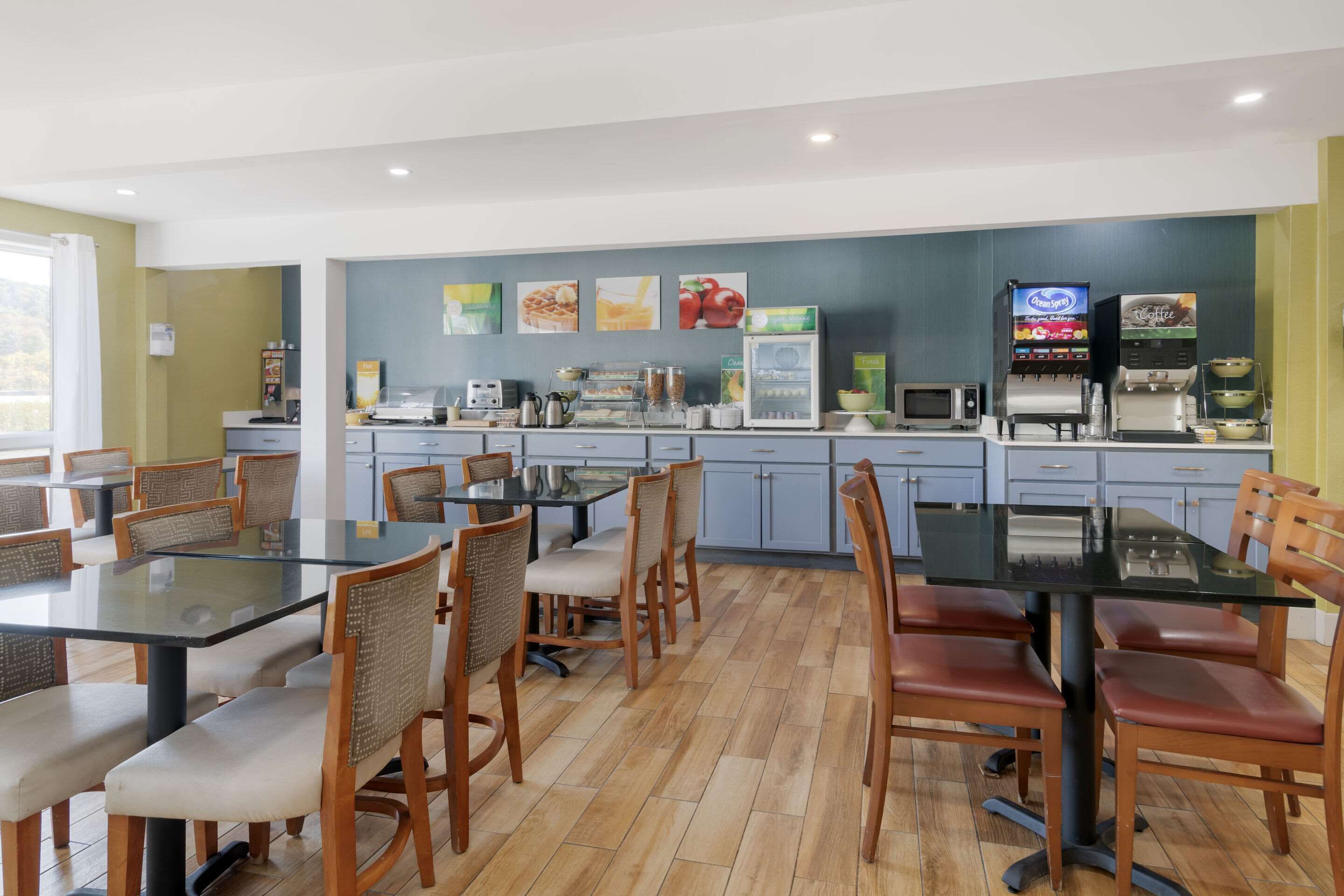 Un restaurante con mostrador, zona de mesas y varios dispensadores de comida y bebidas.