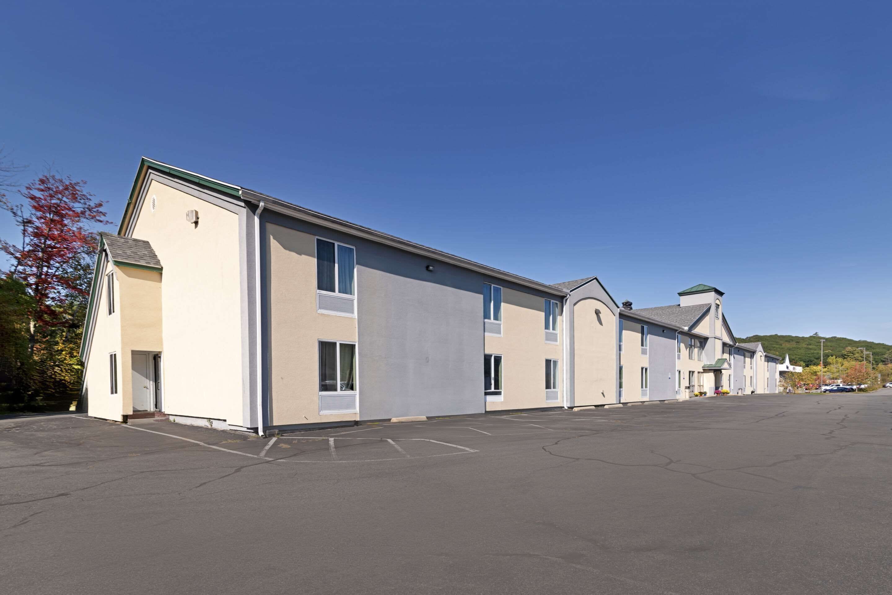 A row of single-story buildings with a parking lot in front.