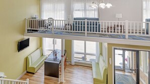 Un espacio habitable amplio con techo alto, un balcón y un comedor.
