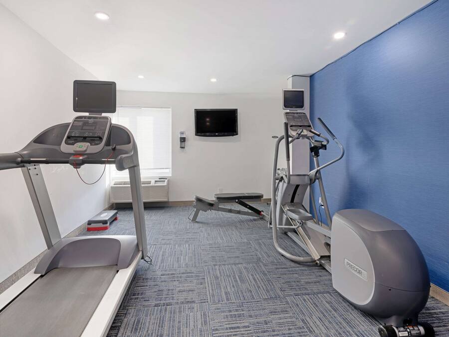 A fitness room with a treadmill, elliptical, and stationary bike.