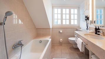 A modern bathroom with a bathtub, shower, toilet, and vanity.