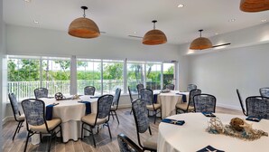 Un salón de conferencias con mesas redondas, sillas e iluminación colgante.