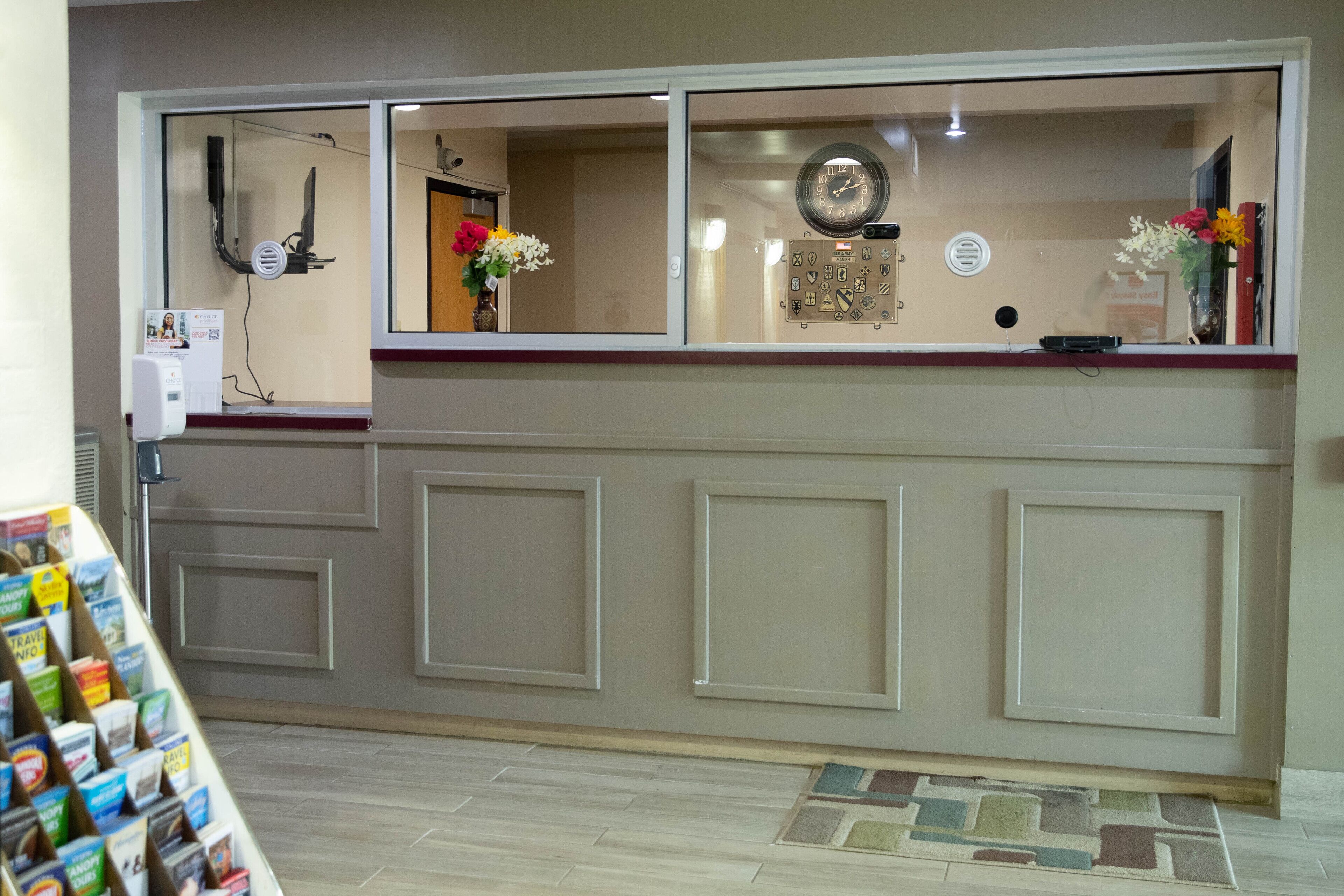 A reception area with a counter, a clock, and a bulletin board.