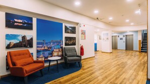 A spacious lobby with wooden flooring, a reception desk, and seating areas. - Travelodge Belfast Central (Belfast)