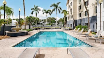 Una piscina al aire libre, tumbonas