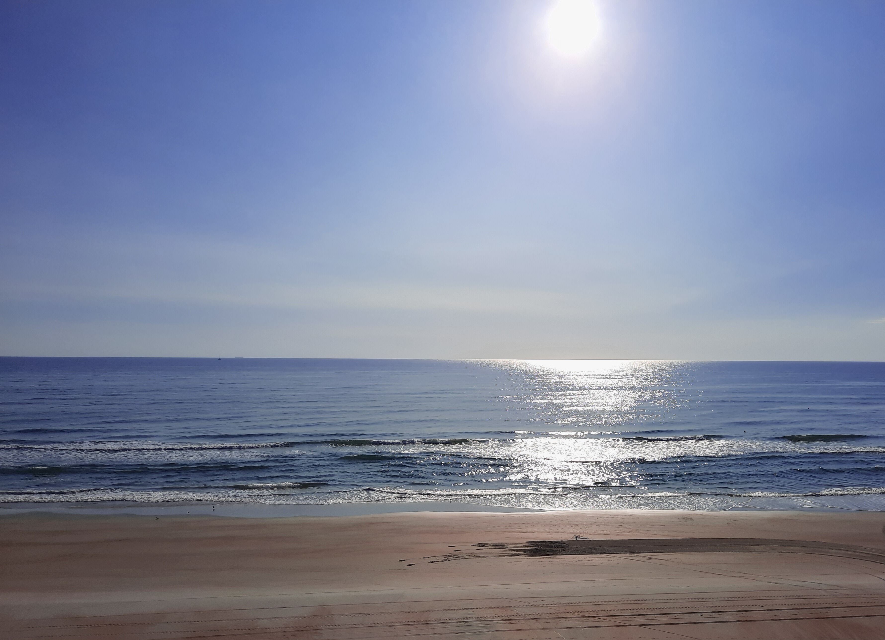 A beach with a clear sky and calm sea.