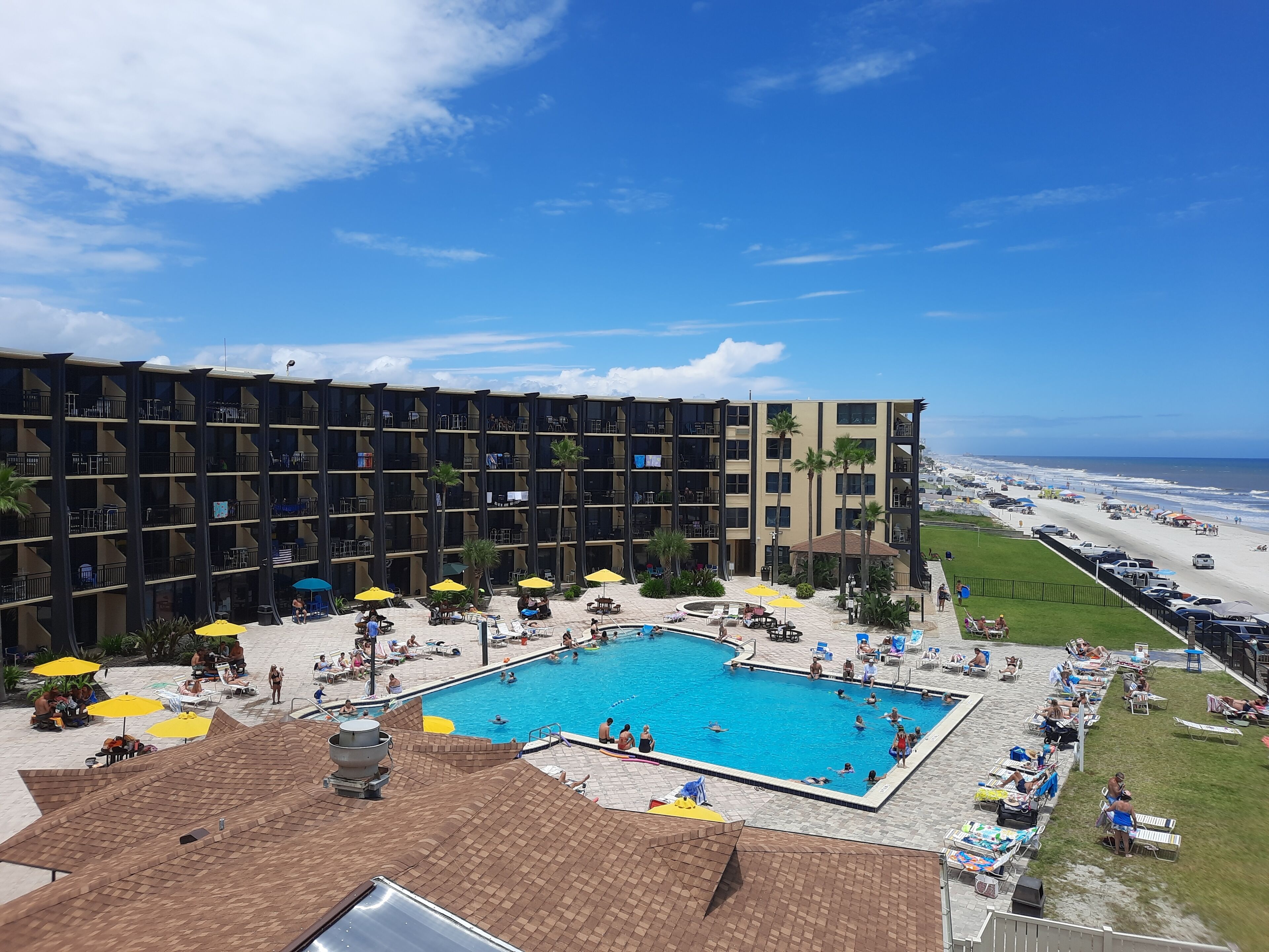 Un hotel con piscina, area relax all'aperto e vista sulla spiaggia.