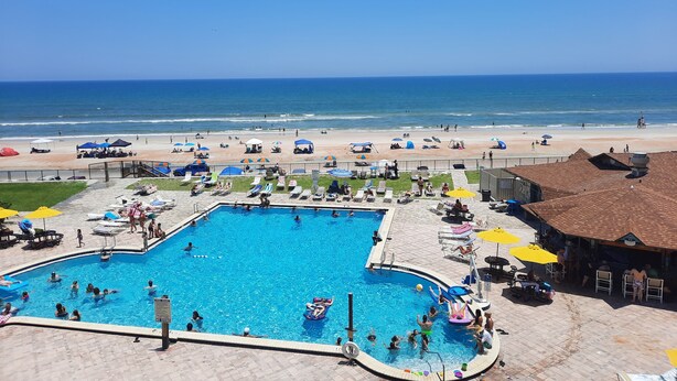 Un espace piscine avec vue sur la plage et l’océan.