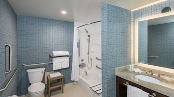 A bathroom with a toilet, shower, and sink.