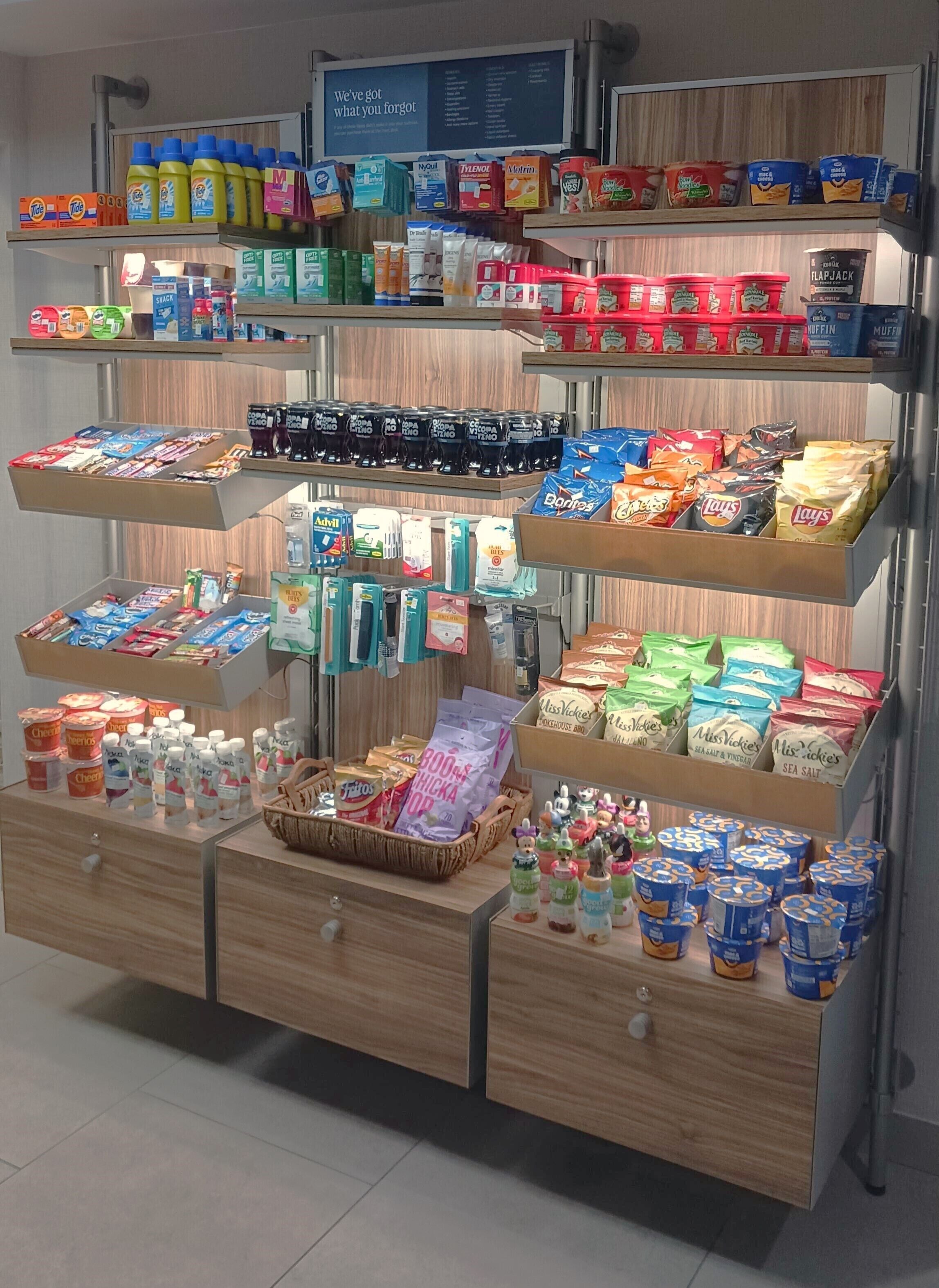 Un supermercado con diversos productos alimenticios y artículos para el hogar en estantes y cajones.