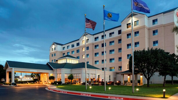 Un hotel con un edificio grande, muchas ventanas y banderas.