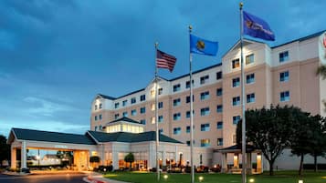 Stunning hotel with a symmetrical facade, featuring a central entrance and landscaped grounds.