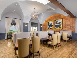 Un restaurante con techos altos, una araña y muebles modernos.