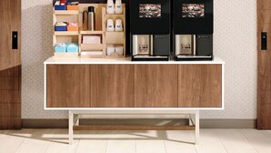 A modern kitchen with wooden cabinets, a white countertop, and a coffee machine. - Holiday Inn Express Hotel & Suites Fort Pierce West by IHG (Fort Pierce)