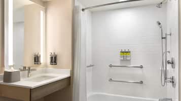 A modern bathroom with a shower, a sink, and a mirror.