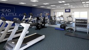 A gym with treadmills, elliptical machines, and weightlifting equipment.