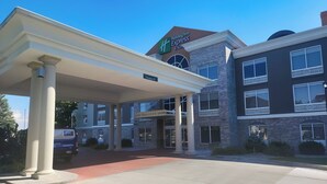 A Holiday Inn Express building with a covered entrance and a clear sky.