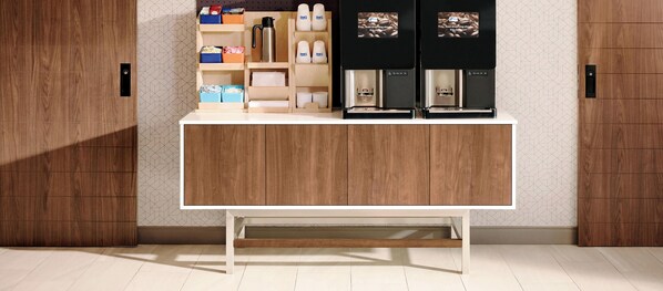 A modern kitchen with a wooden cabinet, two coffee machines, and a shelf with kitchen items. - Holiday Inn Express Suites Plant City by IHG (Plant City)