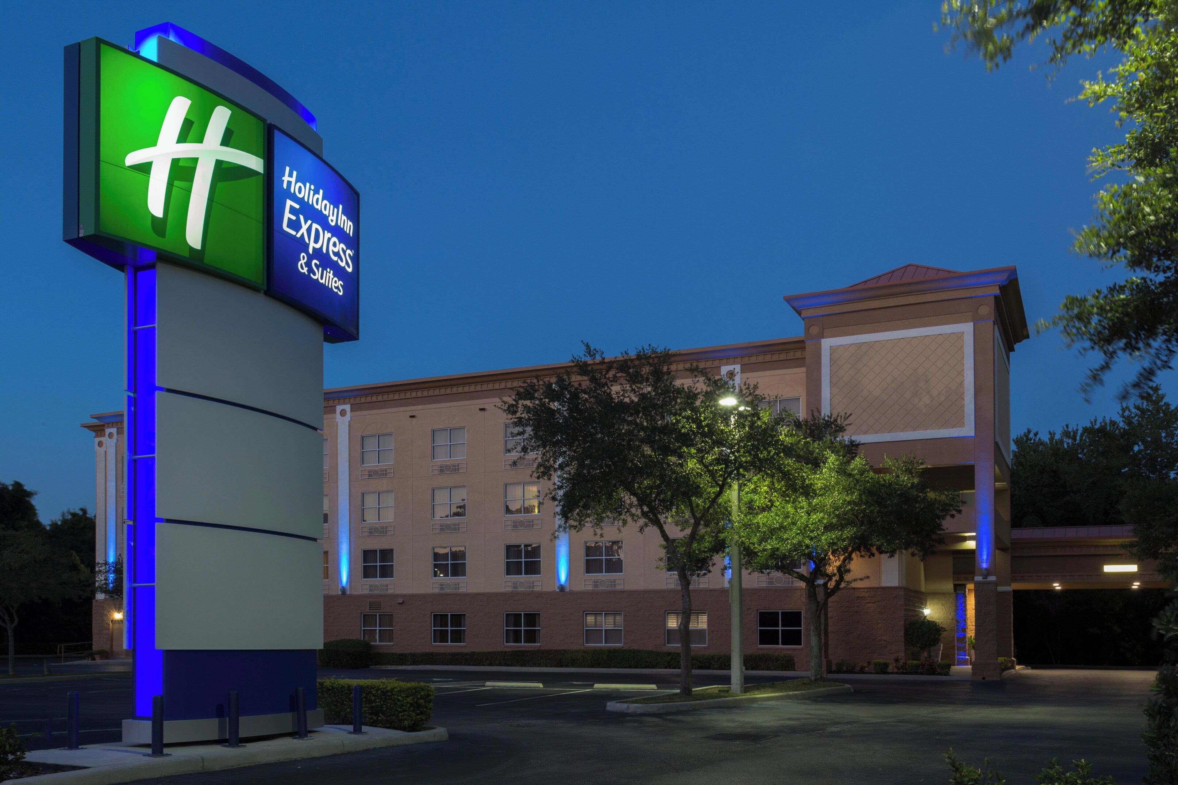 A hotel sign with a green and blue color scheme, indicating a Holiday Inn Express & Suites.