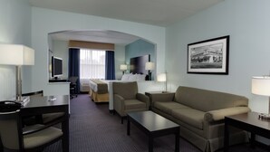 Une chambre d’hôtel avec un lit, un bureau, un canapé et une télévision.