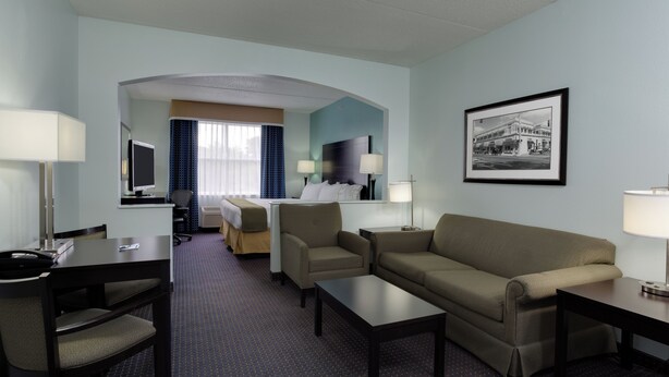 A hotel room with a bed, a desk, a sofa, and a TV. - Holiday Inn Express Suites Plant City by IHG (Plant City)