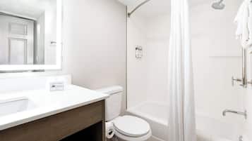 Une salle de bain moderne avec un lavabo, des toilettes et une baignoire, le tout de couleur blanche.