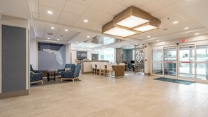 A spacious lobby with a reception desk, seating area with chairs, and a large map on the wall. - Holiday Inn Express Hotels & Suites Cocoa Beach by IHG (Cocoa Beach)