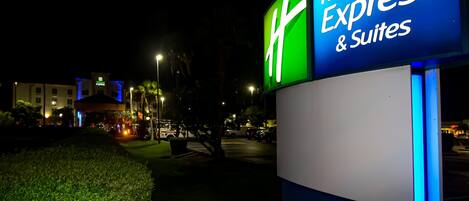 Letrero de Holiday Inn Express con una combinación de colores verde y azul, que indica el nombre del hotel y la disponibilidad de suites.