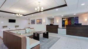 A modern lobby with a reception desk, a sofa area, and artwork on the walls.