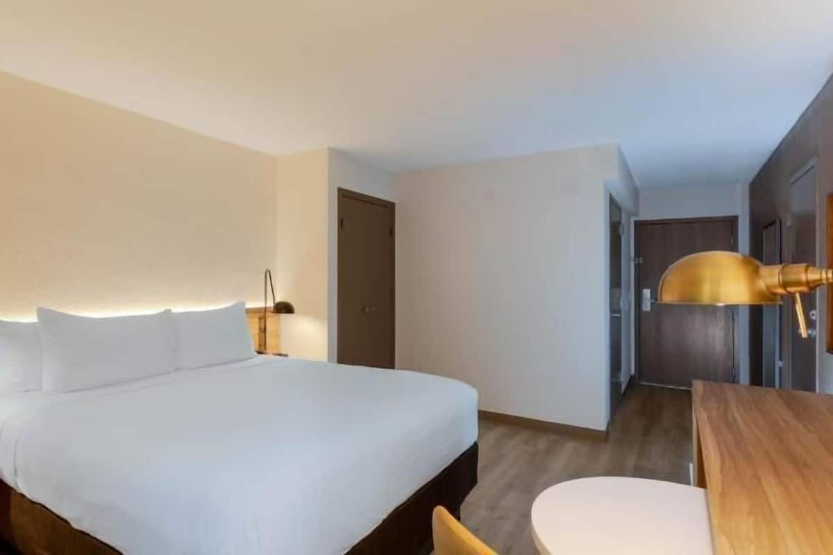 Escritorio, cortinas blackout y tabla de planchar con plancha