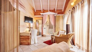 Een ruime slaapkamer met een groot bed, een bureau en een douchehoek.